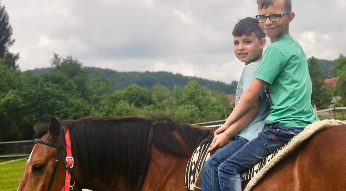 Zwei Jungen auf einem Pferd